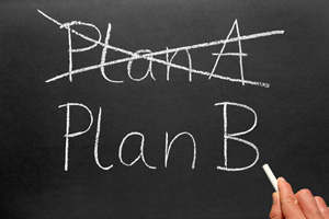 Crossing out Plan A and writing Plan B on a blackboard
